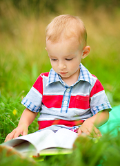 Image showing Little boy is reading book