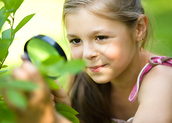 Image showing Girl is looking at tree leaves through magnifier