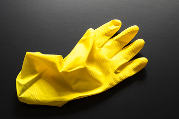 Image showing yellow rubber glove isolated on black background