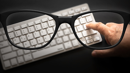 Image showing glasses with keyboard sharp and blurred