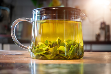 Image showing pot of verbena tea on old wooden table