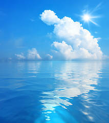 Image showing blue sky with white clouds and sun over the sea