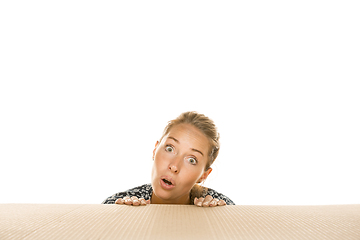 Image showing Young woman opening the biggest postal package isolated on white