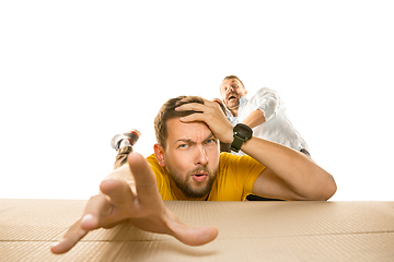 Image showing Young man opening the biggest postal package isolated on white