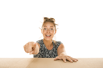 Image showing Young woman opening the biggest postal package isolated on white