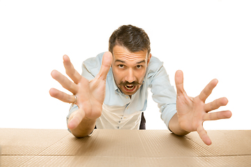 Image showing Young man opening the biggest postal package isolated on white