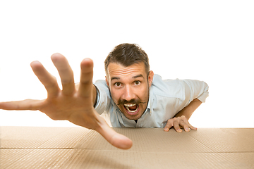 Image showing Young man opening the biggest postal package isolated on white