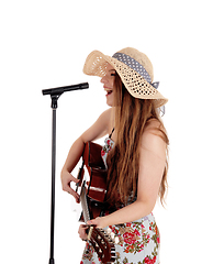 Image showing Woman playing guitar and singing