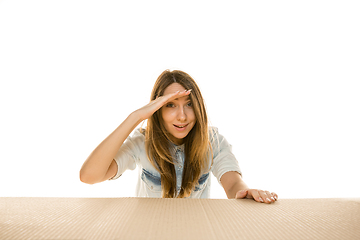 Image showing Young woman opening the biggest postal package isolated on white