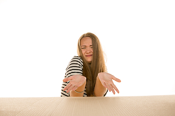 Image showing Young woman opening the biggest postal package isolated on white