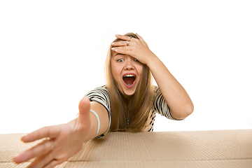 Image showing Young woman opening the biggest postal package isolated on white