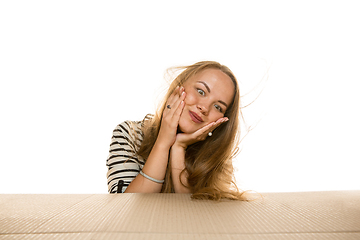 Image showing Young woman opening the biggest postal package isolated on white