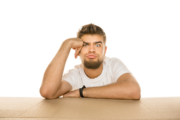 Image showing Young man opening the biggest postal package isolated on white