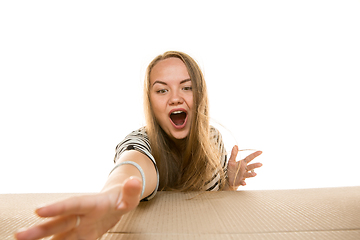 Image showing Young woman opening the biggest postal package isolated on white