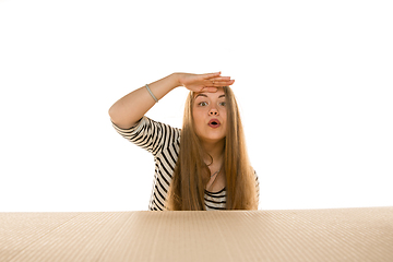 Image showing Young woman opening the biggest postal package isolated on white