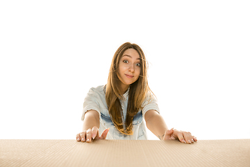 Image showing Young woman opening the biggest postal package isolated on white