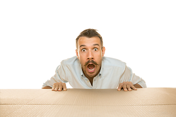 Image showing Young man opening the biggest postal package isolated on white