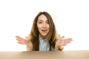 Image showing Young woman opening the biggest postal package isolated on white