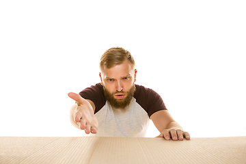 Image showing Young man opening the biggest postal package isolated on white