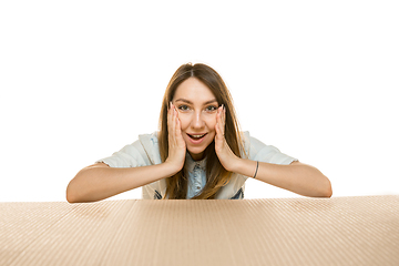 Image showing Young woman opening the biggest postal package isolated on white