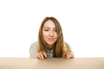 Image showing Young woman opening the biggest postal package isolated on white