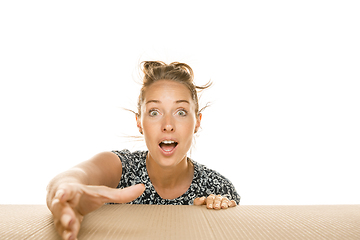 Image showing Young woman opening the biggest postal package isolated on white