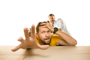 Image showing Young man opening the biggest postal package isolated on white