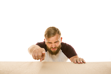 Image showing Young man opening the biggest postal package isolated on white