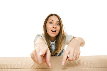 Image showing Young woman opening the biggest postal package isolated on white