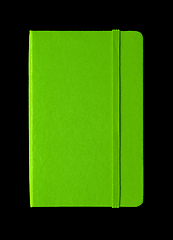 Image showing Green closed notebook isolated on black