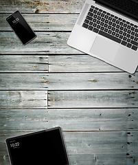 Image showing Laptop, tablet and phone set mockup on a wooden background. 3D r