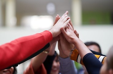 Image showing students together in problem, arm in the air