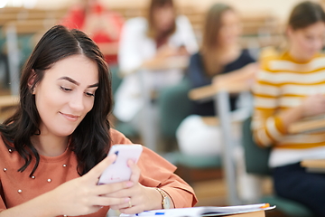 Image showing famel students using smartphone in classroom