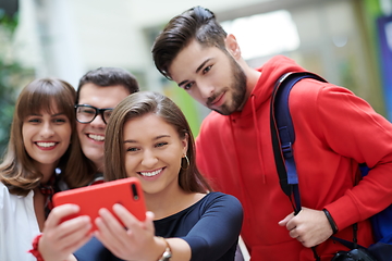 Image showing Group of multiethnic teenagers taking a selfie in school