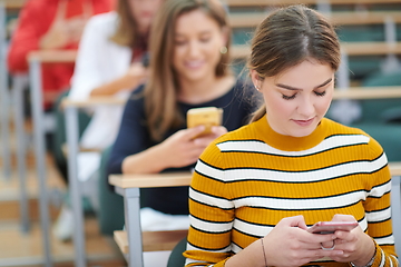 Image showing famel students using smartphone in classroom