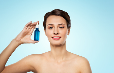 Image showing beautiful young woman with bottle of serum