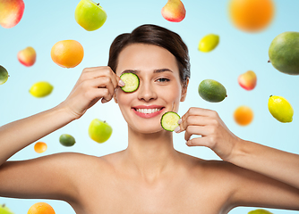 Image showing beautiful woman making eye mask of cucumbers