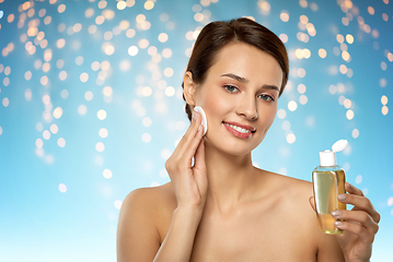 Image showing young woman with toner or cleanser and cotton pad