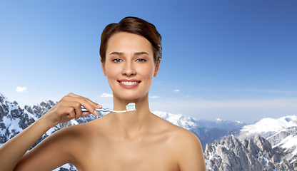 Image showing smiling woman with toothbrush cleaning teeth