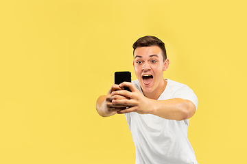 Image showing Caucasian young man\'s half-length portrait on yellow background