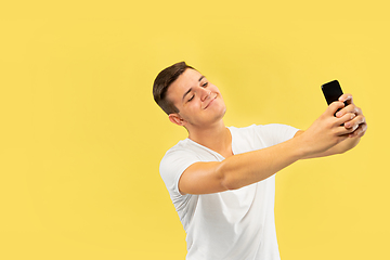 Image showing Caucasian young man\'s half-length portrait on yellow background