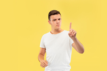 Image showing Caucasian young man\'s half-length portrait on yellow background