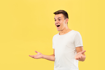 Image showing Caucasian young man\'s half-length portrait on yellow background