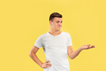 Image showing Caucasian young man\'s half-length portrait on yellow background