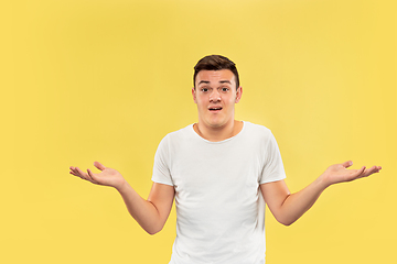 Image showing Caucasian young man\'s half-length portrait on yellow background