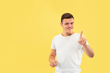 Image showing Caucasian young man\'s half-length portrait on yellow background