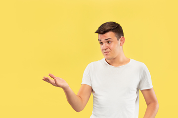 Image showing Caucasian young man\'s half-length portrait on yellow background