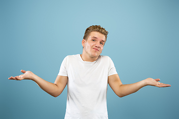 Image showing Caucasian young man\'s half-length portrait on blue background