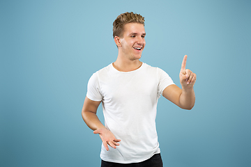 Image showing Caucasian young man\'s half-length portrait on blue background