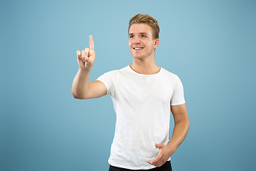 Image showing Caucasian young man\'s half-length portrait on blue background